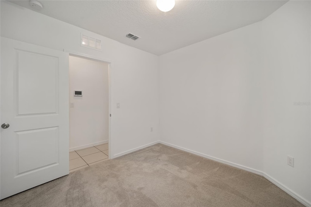 carpeted empty room with a textured ceiling