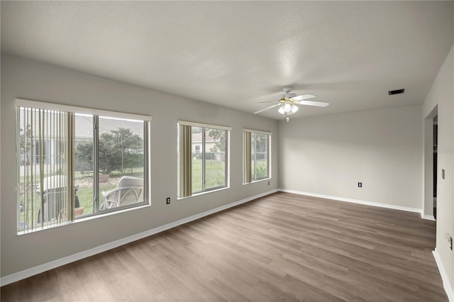 spare room featuring a textured ceiling, wood-type flooring, and ceiling fan