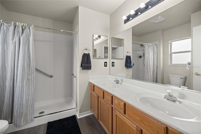 bathroom with a shower with shower curtain, wood-type flooring, toilet, and vanity