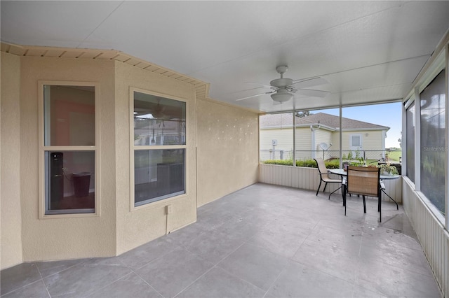 unfurnished sunroom with ceiling fan