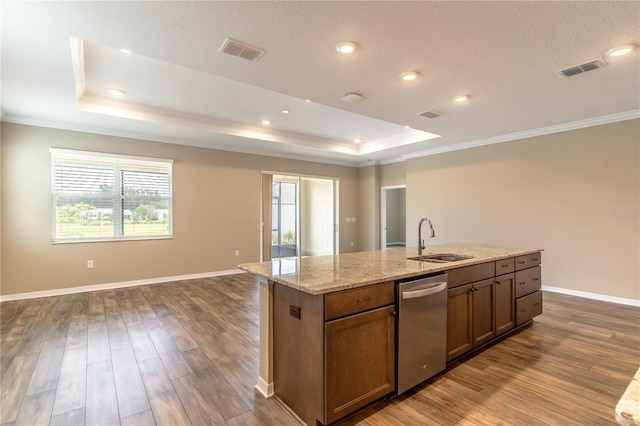 kitchen with dishwasher, a tray ceiling, a sink, and visible vents