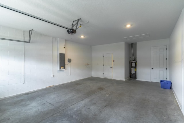 garage featuring water heater, concrete block wall, electric panel, and a garage door opener