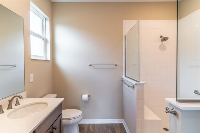 bathroom featuring wood finished floors, baseboards, toilet, and walk in shower