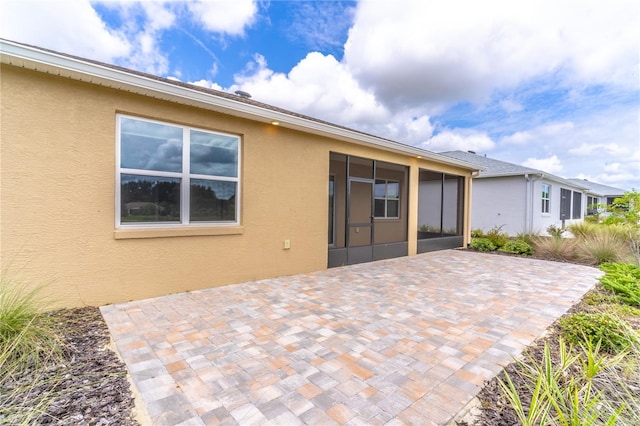 9994 SW 96th St, Ocala, FL 34481 - rear view of house with a sunroom, a patio area, and stucco siding
