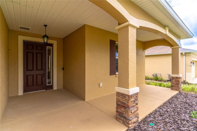 9994 SW 96th St, Ocala, FL 34481 - view of exterior entry featuring visible vents and stucco siding
