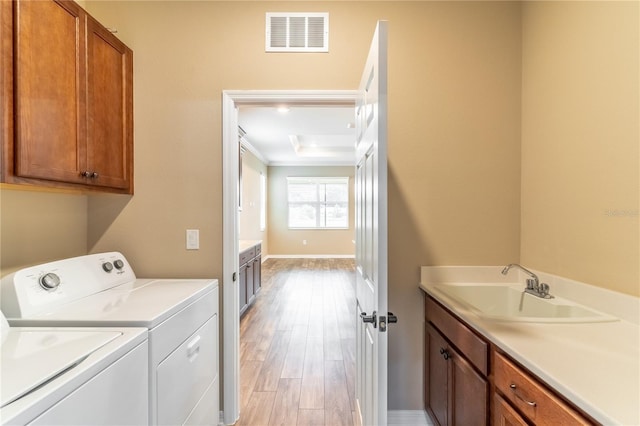 9994 SW 96th St, Ocala, FL 34481 - laundry room featuring visible vents, a sink, light wood-style floors, independent washer and dryer, and cabinet space