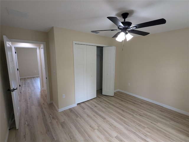 unfurnished bedroom with a closet, light hardwood / wood-style floors, and ceiling fan