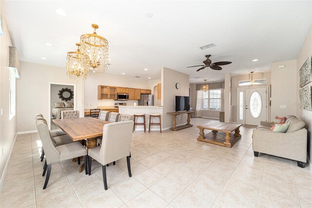 dining area with ceiling fan with notable chandelier and light tile patterned flooring