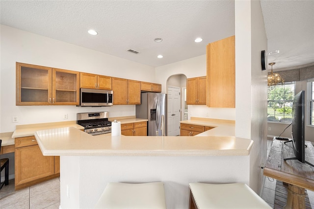 kitchen featuring appliances with stainless steel finishes, kitchen peninsula, and a breakfast bar area