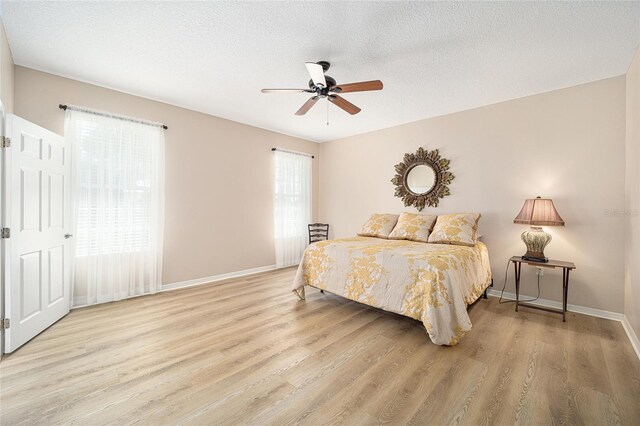 bedroom featuring a textured ceiling, ceiling fan, and light hardwood / wood-style floors