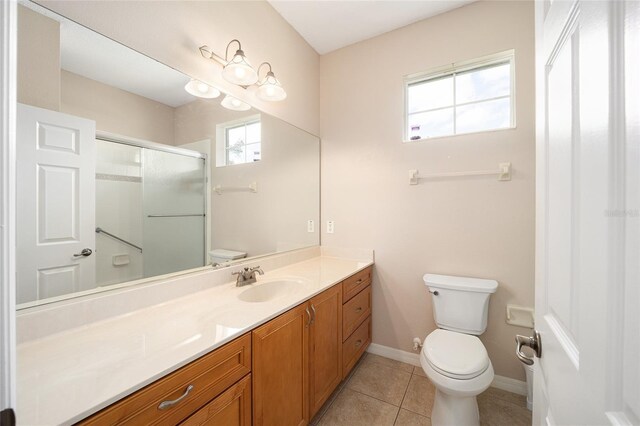 bathroom with tile patterned floors, toilet, a shower with door, and vanity