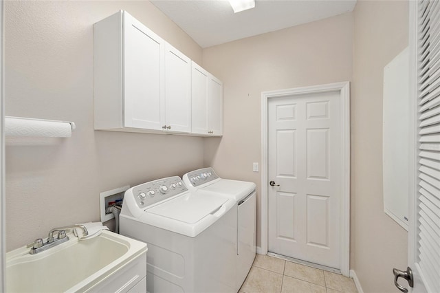 laundry area with separate washer and dryer, light tile patterned floors, cabinets, and sink