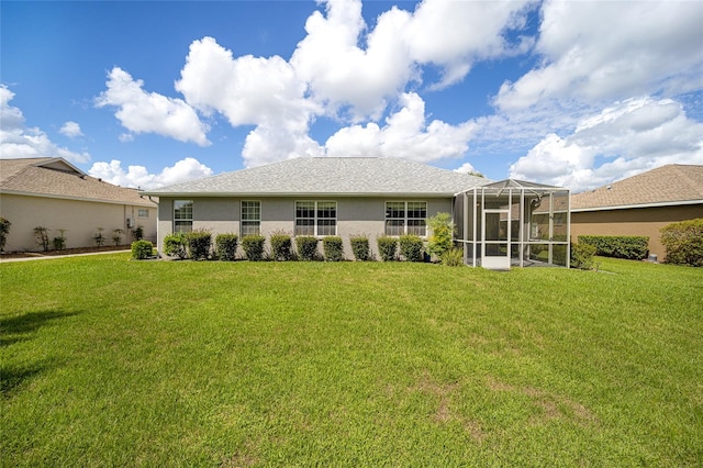 rear view of house featuring a yard and a lanai