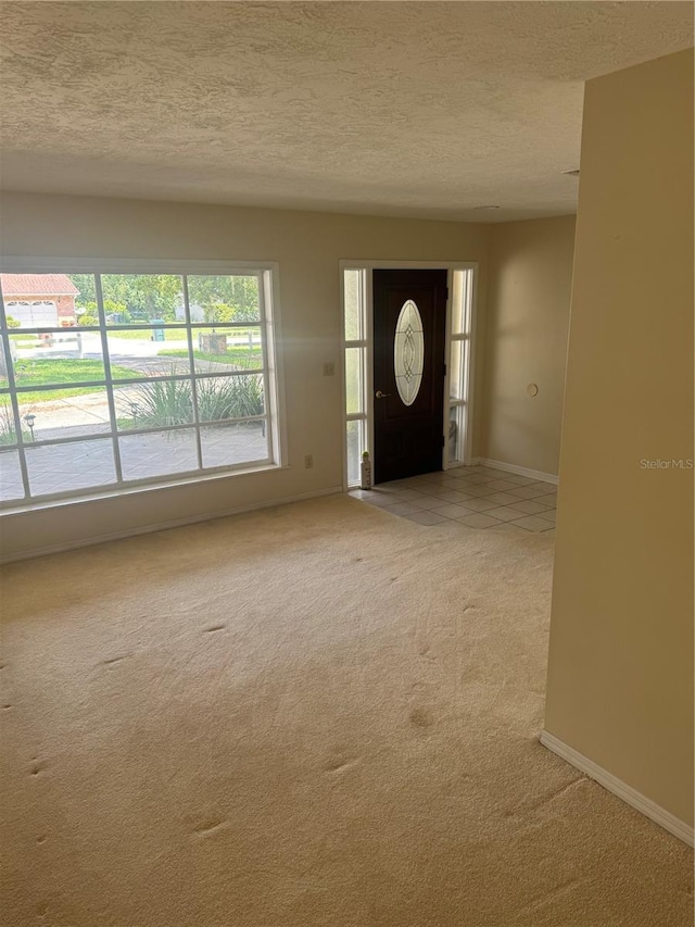 carpeted entrance foyer featuring a textured ceiling