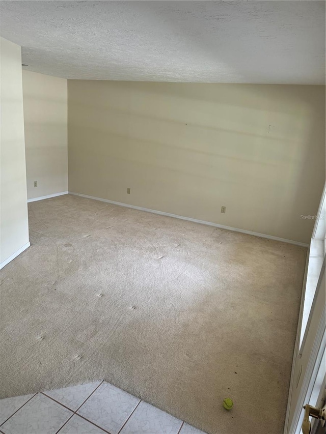 carpeted spare room featuring a textured ceiling