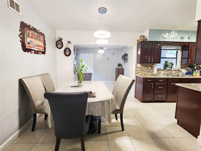 dining room with ceiling fan, light tile patterned floors, and sink