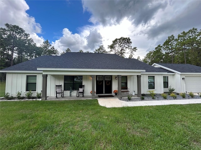 ranch-style home featuring a garage, a porch, and a front lawn