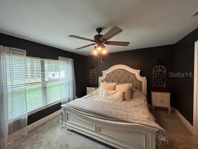 carpeted bedroom featuring a textured ceiling and ceiling fan