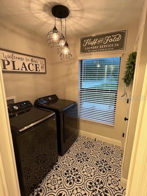 laundry room featuring washing machine and dryer and light tile patterned floors