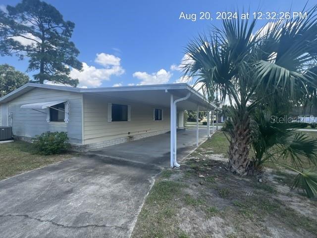 view of front of property featuring central AC unit and a carport