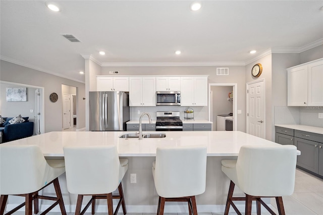 kitchen featuring backsplash, visible vents, stainless steel appliances, and a sink