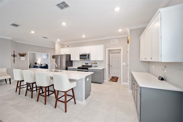 kitchen featuring appliances with stainless steel finishes, visible vents, crown molding, and decorative backsplash