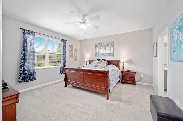 bedroom with ceiling fan, baseboards, connected bathroom, and light colored carpet