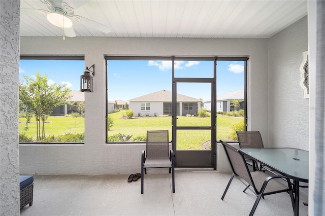 sunroom / solarium featuring a residential view and ceiling fan