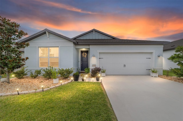 ranch-style house featuring a garage and a lawn