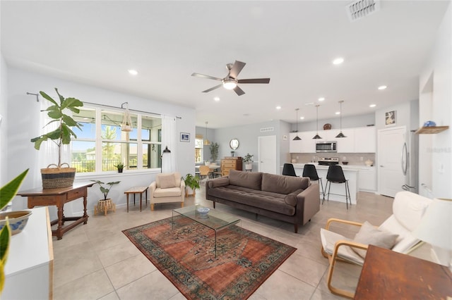 living room featuring light tile patterned floors and ceiling fan