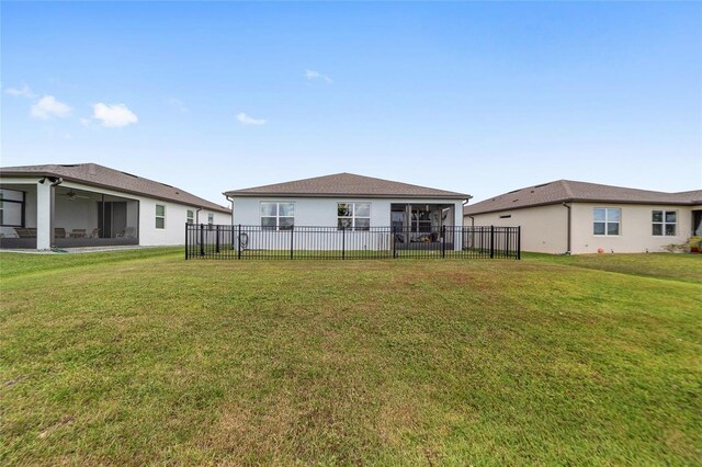 back of house with a sunroom and a yard