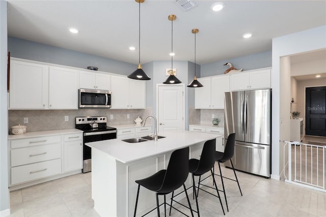 kitchen featuring appliances with stainless steel finishes, sink, a center island with sink, and white cabinets