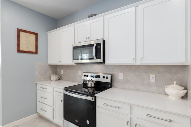 kitchen featuring white cabinetry, appliances with stainless steel finishes, tasteful backsplash, and light tile patterned floors