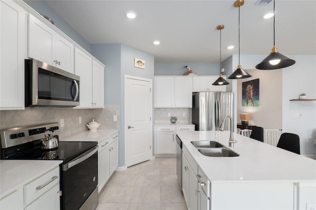 kitchen featuring white cabinetry, sink, stainless steel appliances, and an island with sink