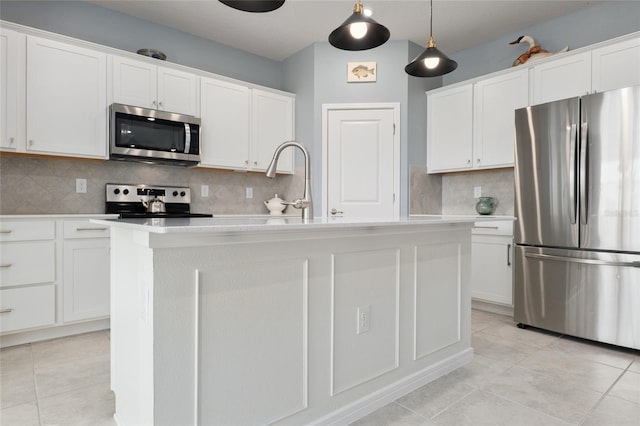 kitchen featuring stainless steel appliances, a kitchen island with sink, hanging light fixtures, and white cabinets