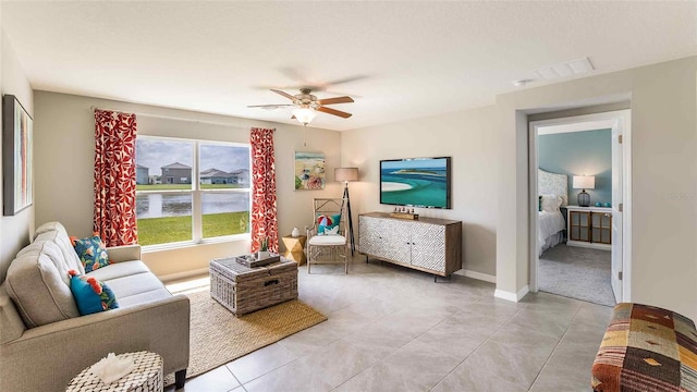 living room with visible vents, ceiling fan, baseboards, and light tile patterned floors