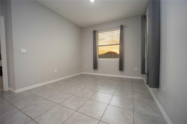 tiled spare room with vaulted ceiling