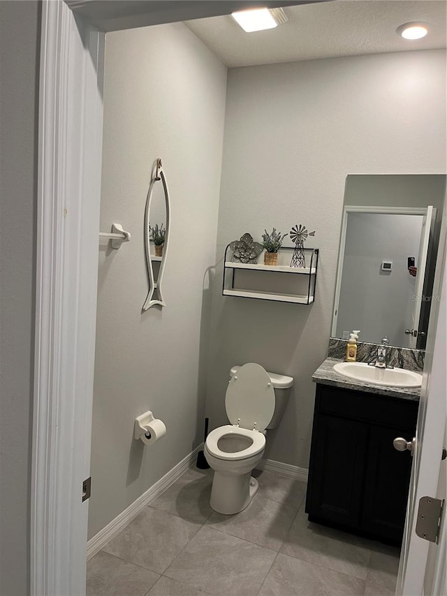 bathroom featuring tile patterned flooring, vanity, and toilet