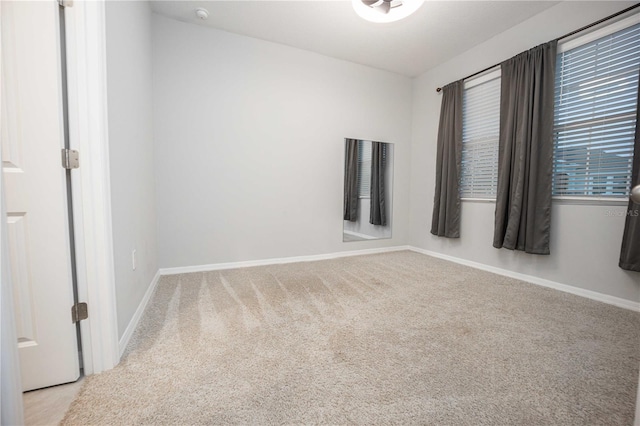 unfurnished room featuring light carpet