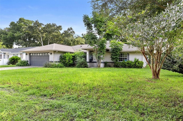 single story home featuring a front lawn, concrete driveway, an attached garage, and stucco siding