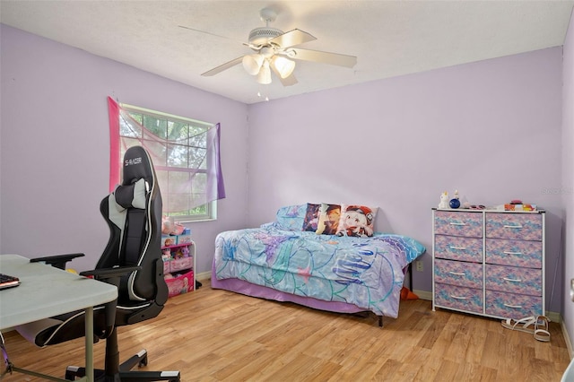 bedroom featuring wood finished floors, a ceiling fan, and baseboards