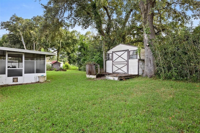 view of yard with a sunroom, an outdoor structure, and a shed