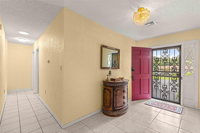 tiled entryway with a textured ceiling