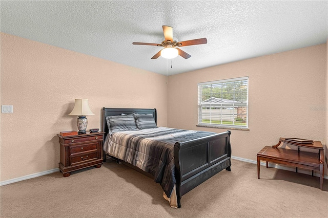 bedroom with a textured ceiling, light colored carpet, and ceiling fan