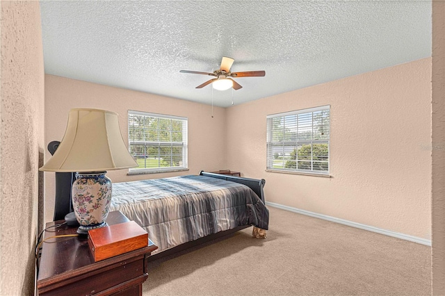 carpeted bedroom with a textured ceiling and ceiling fan