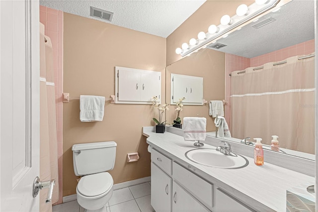 bathroom with a textured ceiling, vanity, toilet, and tile patterned floors