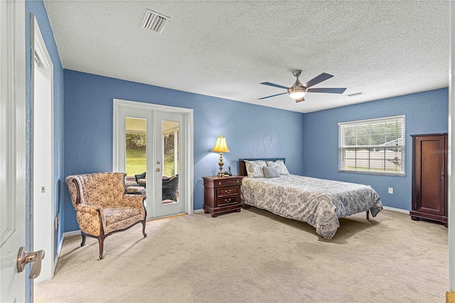 bedroom featuring a textured ceiling, access to outside, ceiling fan, french doors, and light colored carpet