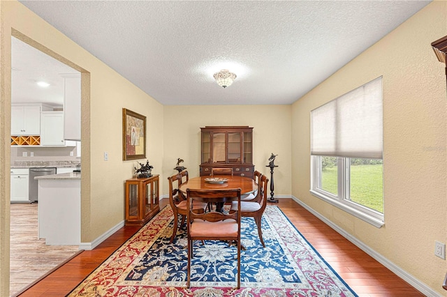 dining space featuring a textured ceiling and light hardwood / wood-style flooring