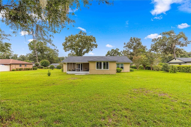 back of house with a sunroom and a lawn