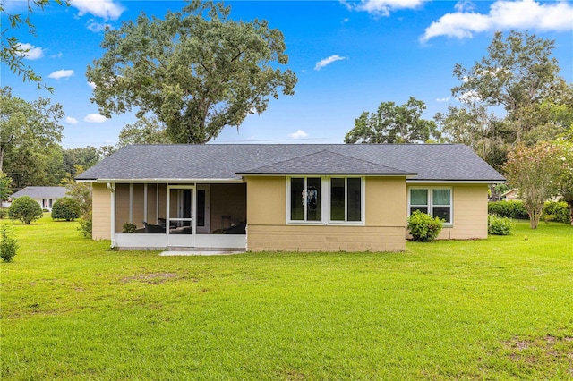 rear view of house with a yard and a sunroom